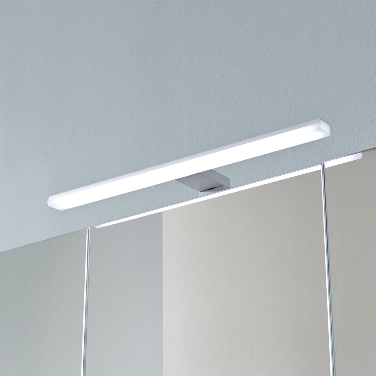 Moderne ledlamp op een spiegelkast, gezien vanaf de voorkant