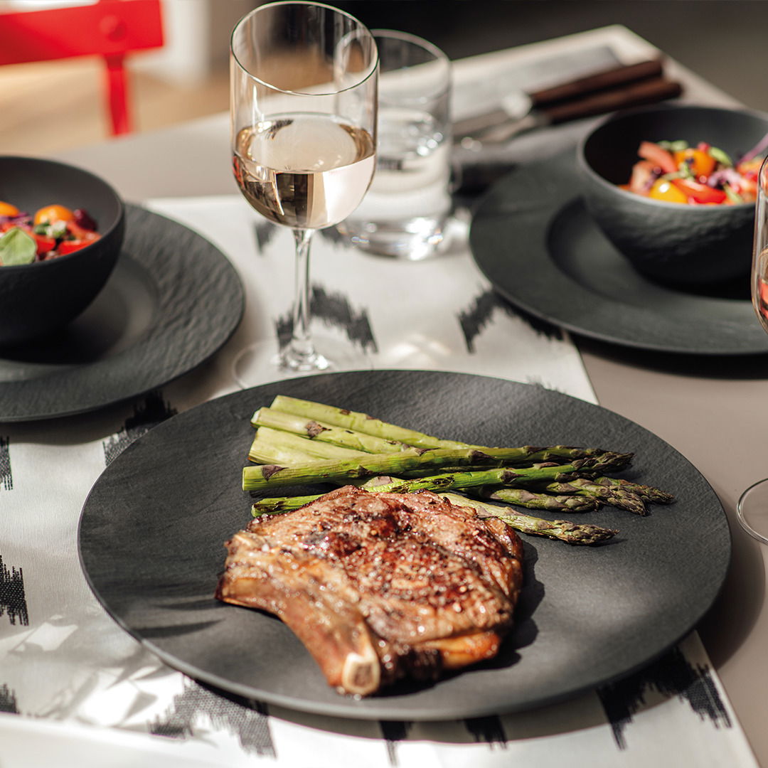 Villeroy & Boch Speiseteller MANUFACTURE ROCK Gourmetteller Manufacture 25cm mit einem saftigen Steak und Spargel, von oben betrachtet, auf einem stilvoll gedeckten Tisch mit Weinglas.