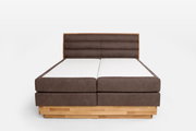 Frontale Ansicht eines Boxspringbetts mit braunem Polsterkopfteil und Holzrahmen.
