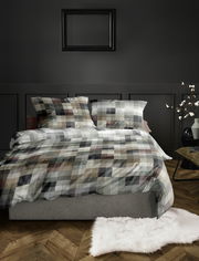 Bettwäsche-Set mit kariertem Muster in Erdtönen auf einem Bett, fotografiert aus der Vorderansicht in einem stilvoll eingerichteten Schlafzimmer.