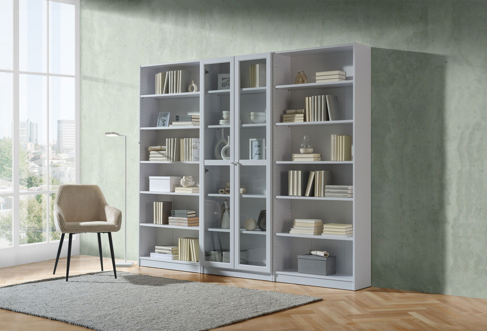 Frontale Ansicht eines modernen weißen Regals mit mehreren Fächern, gefüllt mit Büchern und Dekorationen, neben einem beigen Stuhl in einem hellen Raum.