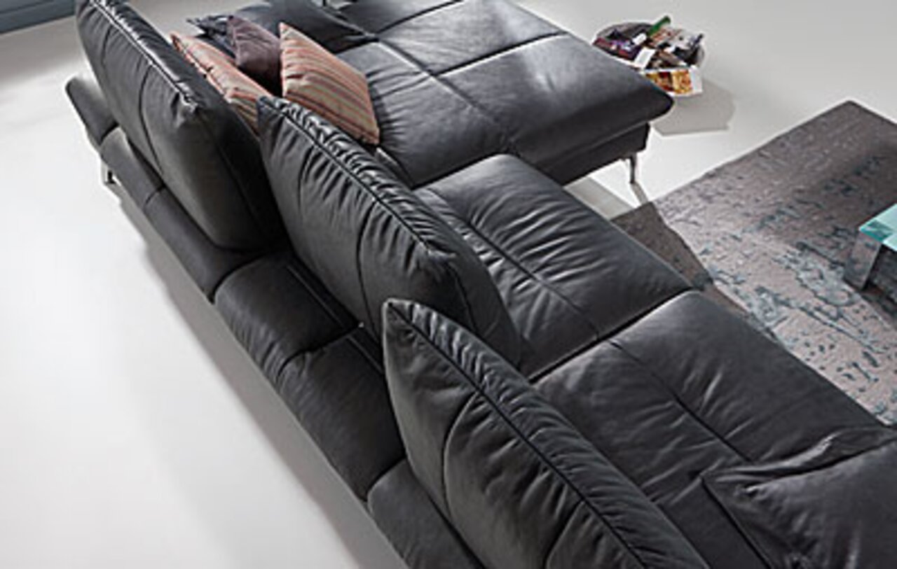 Schwarzes 2,5-sitziges Sofa aus der Vogelperspektive mit mehreren Kissen.