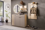Modernes Flur-Set aus hellem Holz mit grauen Fronten: Sideboard mit Lamellenoptik, runder Wandspiegel mit LED-Hinterleuchtung, Wandregal und Garderobenpaneel mit Hutablage und Kleiderhaken, frontal in leichter Schrägansicht von links fotografiert.