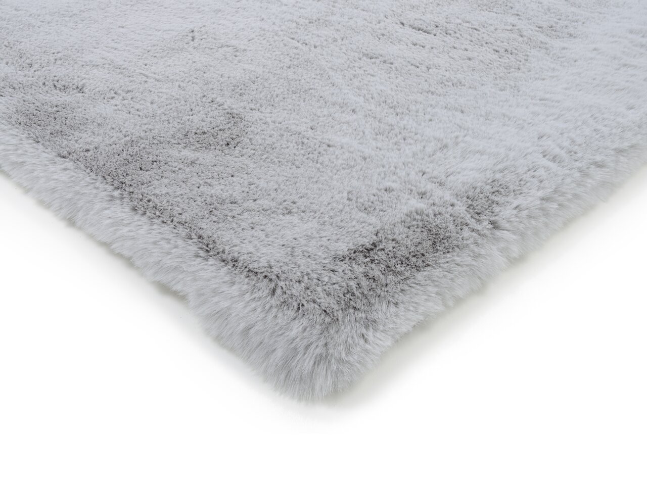 Grauer Fellteppich in Nahaufnahme, perspektivisch von der Seite fotografiert