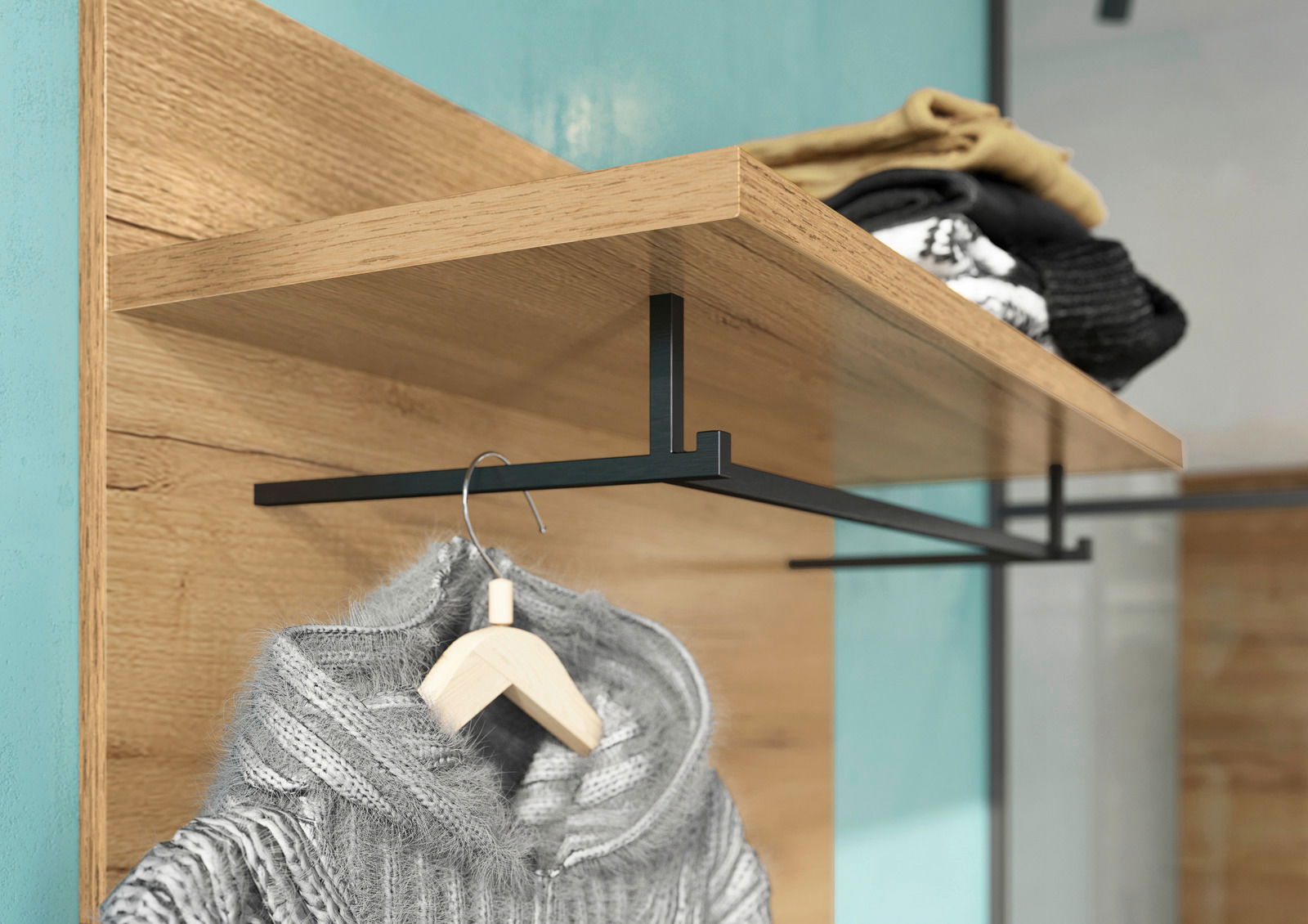 Garderobenpaneel aus Holz mit schwarzer Metallstange, darauf liegende Kleidung und ein hängender Pullover, seitliche Perspektive