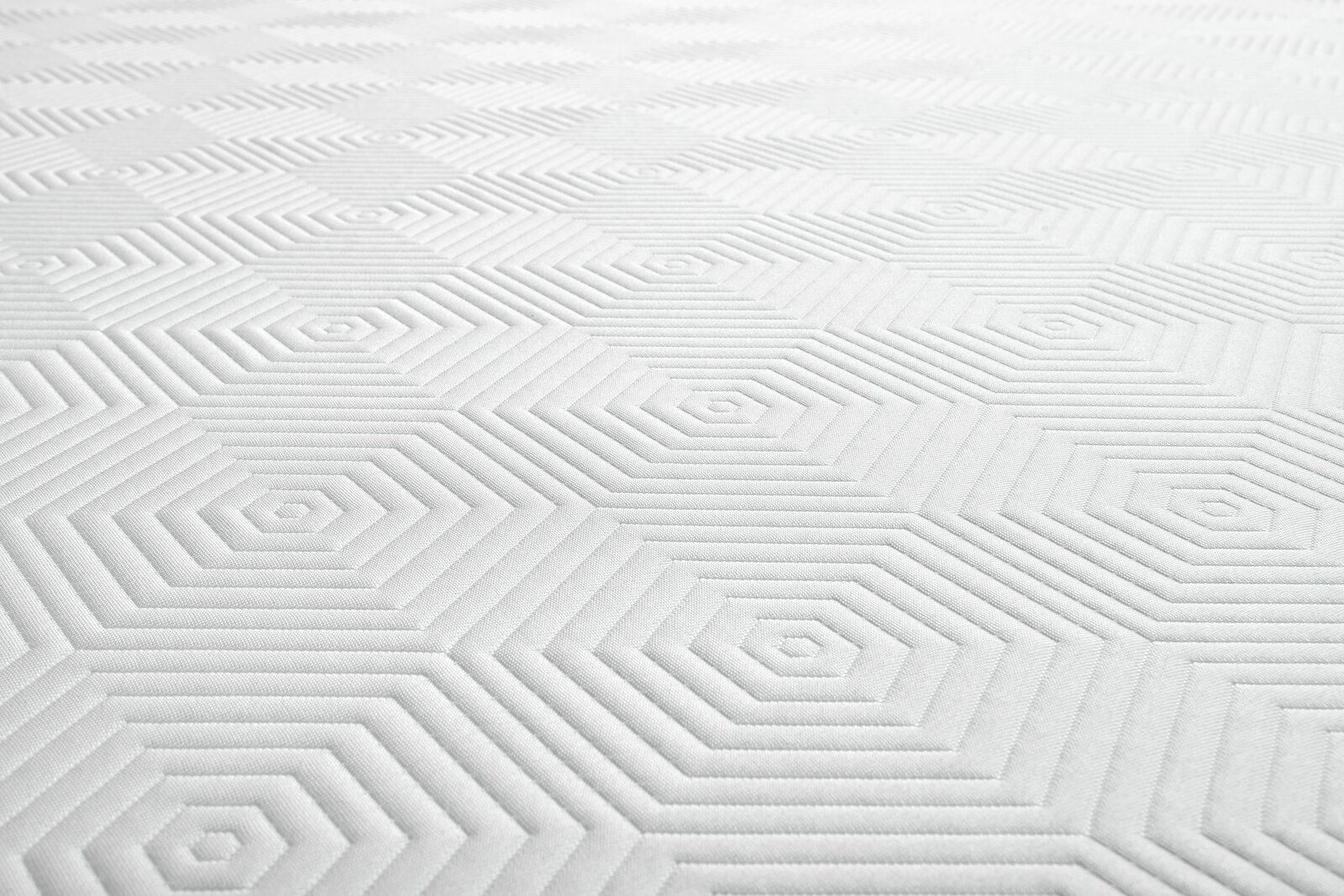 Nahaufnahme einer Viscomatratze mit geometrischem Muster in Weiß.