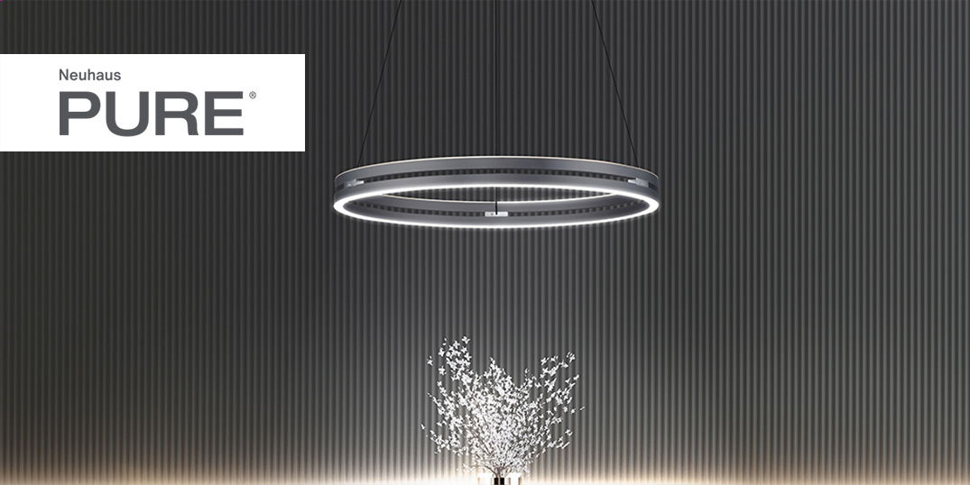 Runde, moderne Hängelampe leuchtet über einem dekorativen Strauß vor dunkler Wand.