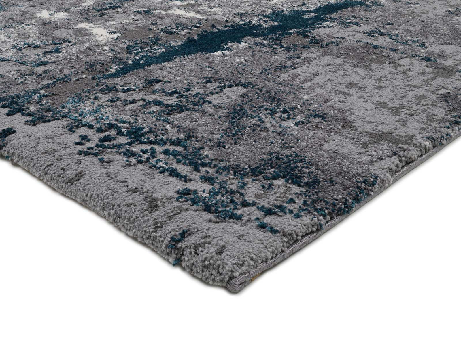 Nahaufnahme eines modernen Teppichs mit grauen und blauen Mustern, perspektivisch von der Seite aufgenommen.