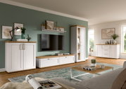 Wohnkombination VERONA in einem modernen Wohnzimmer mit grüner Wand, bestehend aus TV-Schrank, Vitrine und Sideboard in Holzoptik, aus seitlicher Perspektive betrachtet.