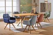 Esszimmer mit einem Holztisch und verschiedenen farbigen Sesseln aus der Serie COZY, seitliche Perspektive.