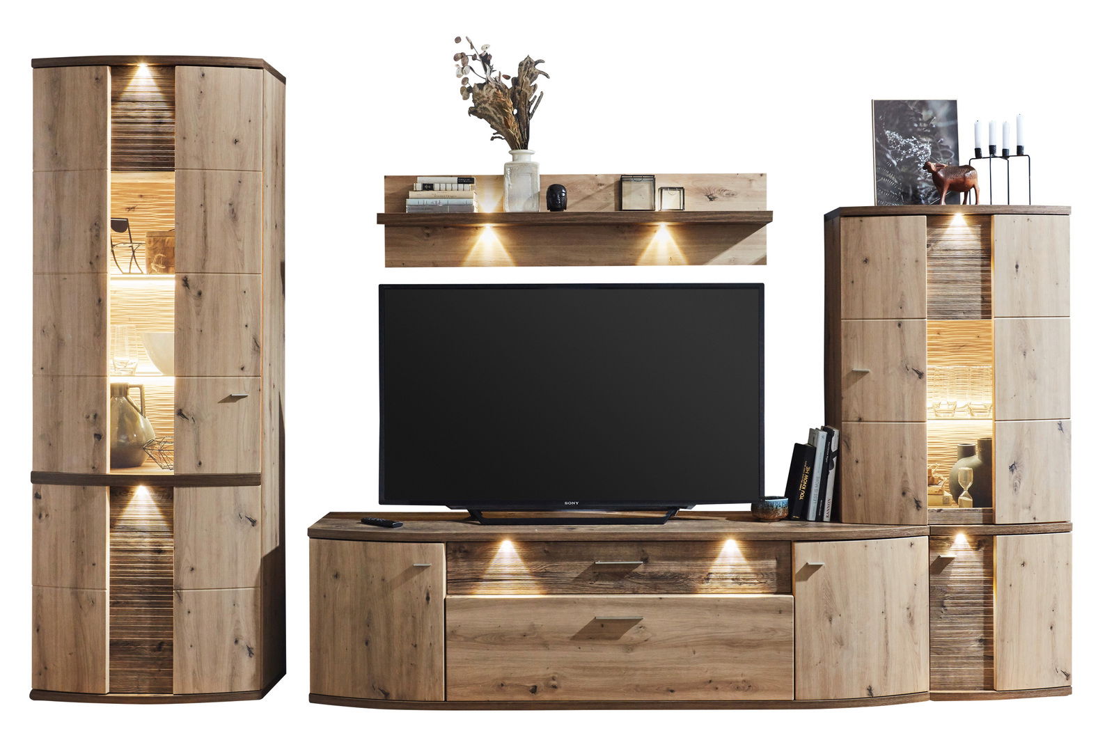 Moderne Wandkombination aus Holz mit Beleuchtung, bestehend aus zwei Vitrinenschränken, einem TV-Board und einem Wandregal. Frontalansicht.