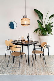 Moderner Esstisch FABIO mit schwarzer Tischplatte und Holzstühlen, dekoriert mit Geschirr und Weingläsern, aus der Perspektive von vorne betrachtet.