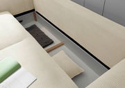 Detailansicht eines Funktionssofas mit geöffneter Aufbewahrung, beige gestreifter Stoff, von oben betrachtet.