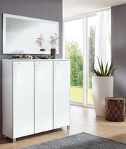 Moderner rechteckiger Spiegel an der Wand über einem weißen Schrank, mit Pflanzen und Dekorationen, in einem hellen Raum mit großen Fenstern, seitliche Perspektive.