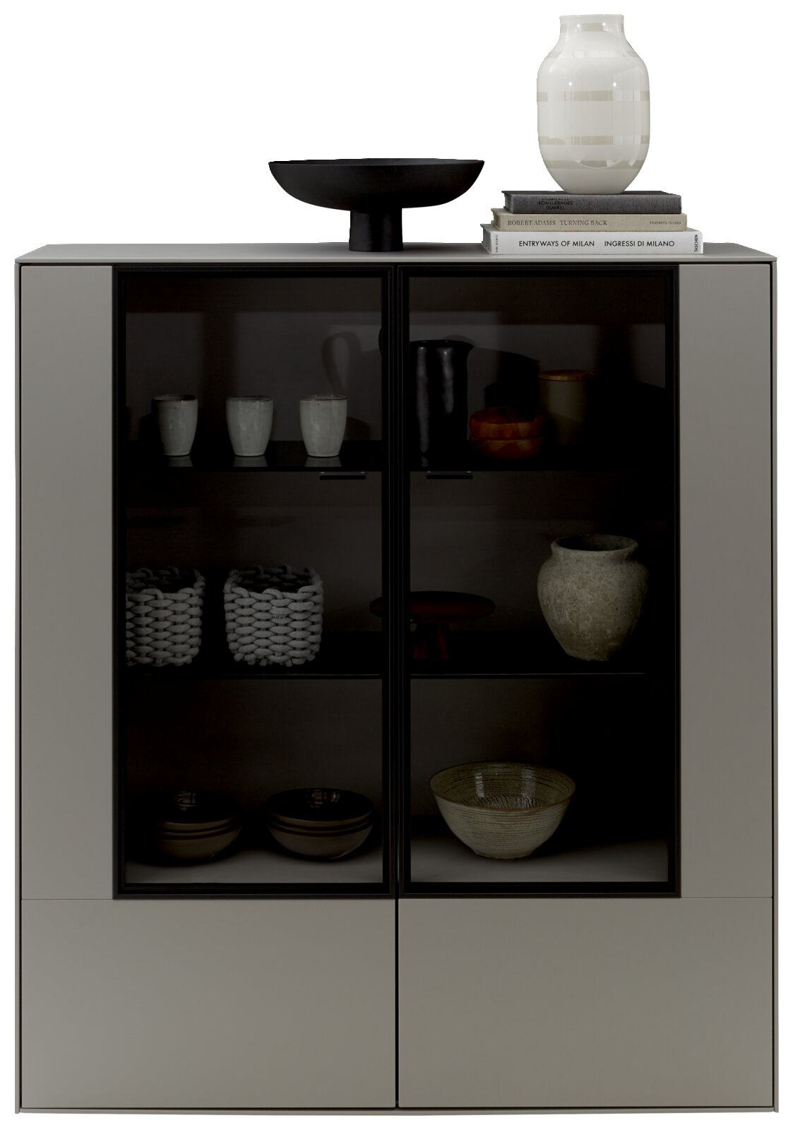 Modernes Highboard mit Glasfronten, dekoriert mit Keramik und Büchern, aus frontaler Perspektive.