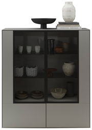 Modernes Highboard mit Glasfronten, dekoriert mit Keramik und Büchern, aus frontaler Perspektive.