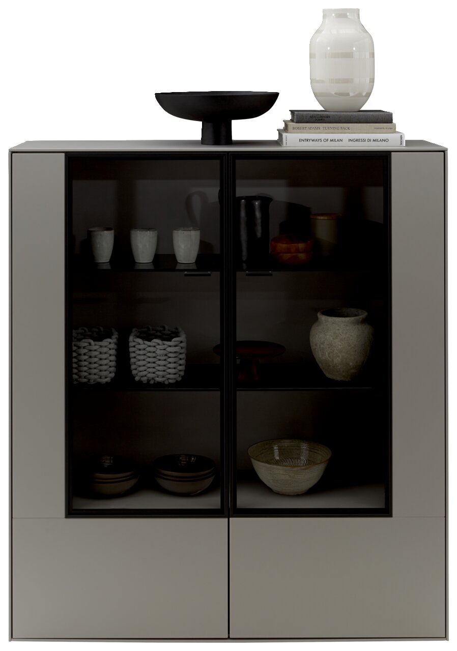 Modernes Highboard mit Glasfronten, dekoriert mit Keramik und Büchern, aus frontaler Perspektive.