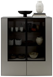 Modernes Highboard mit Glasfronten, dekoriert mit Keramik und Büchern, aus frontaler Perspektive.