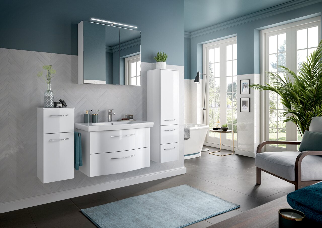 Moderner Badblock in einem stilvollen Badezimmer mit weißem Waschtisch, Hängeschrank und hohem Schrank, aus der Perspektive von vorne links betrachtet.