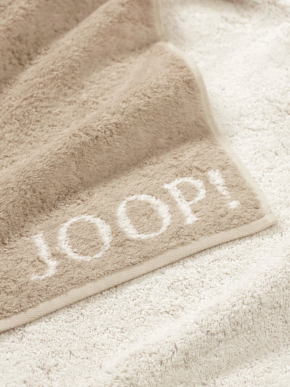 Beiges Duschtuch mit eingewebtem Schriftzug 'JOOP!' in Nahaufnahme