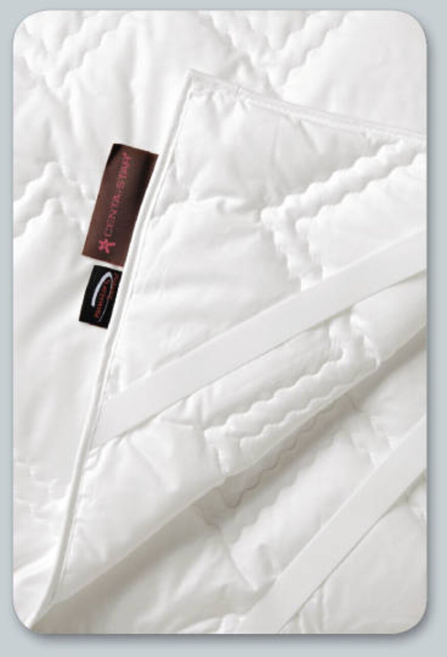 Vital-Unterbett 90x200 cm in Nahaufnahme, zeigt die weiße, gesteppte Oberfläche mit Etikett und elastischen Bändern.