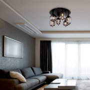 Moderne Deckenleuchte mit mehreren Glaskugeln, die von der Decke eines stilvollen Wohnzimmers hängt, seitliche Perspektive.
