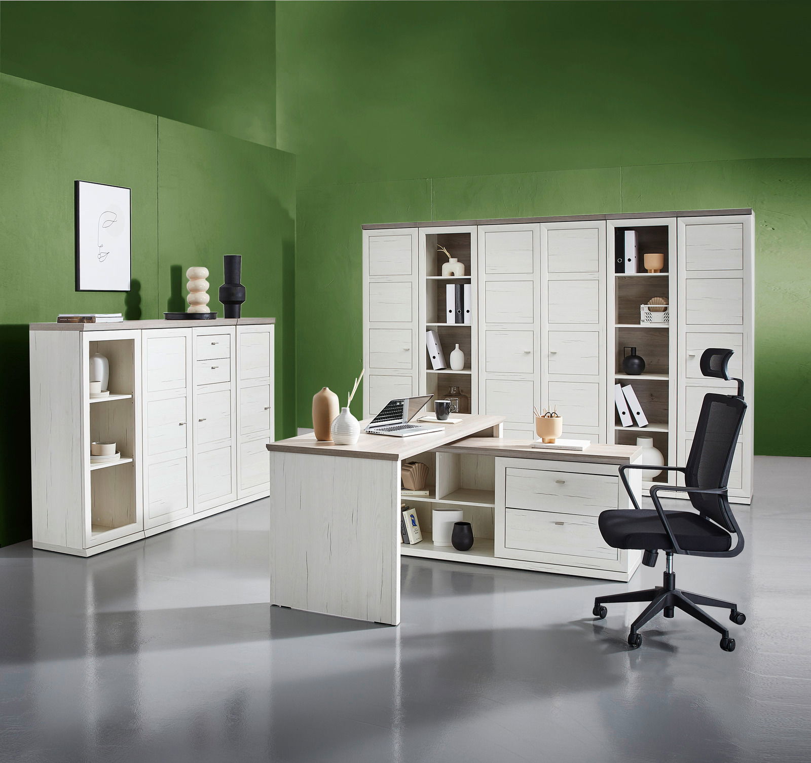 Moderne Büromöbelkombination mit weißem Eckschreibtisch, Drehstuhl und mehreren Aktenschränken in einem stilvollen Raum mit grüner Wand. Perspektive: Frontalansicht.