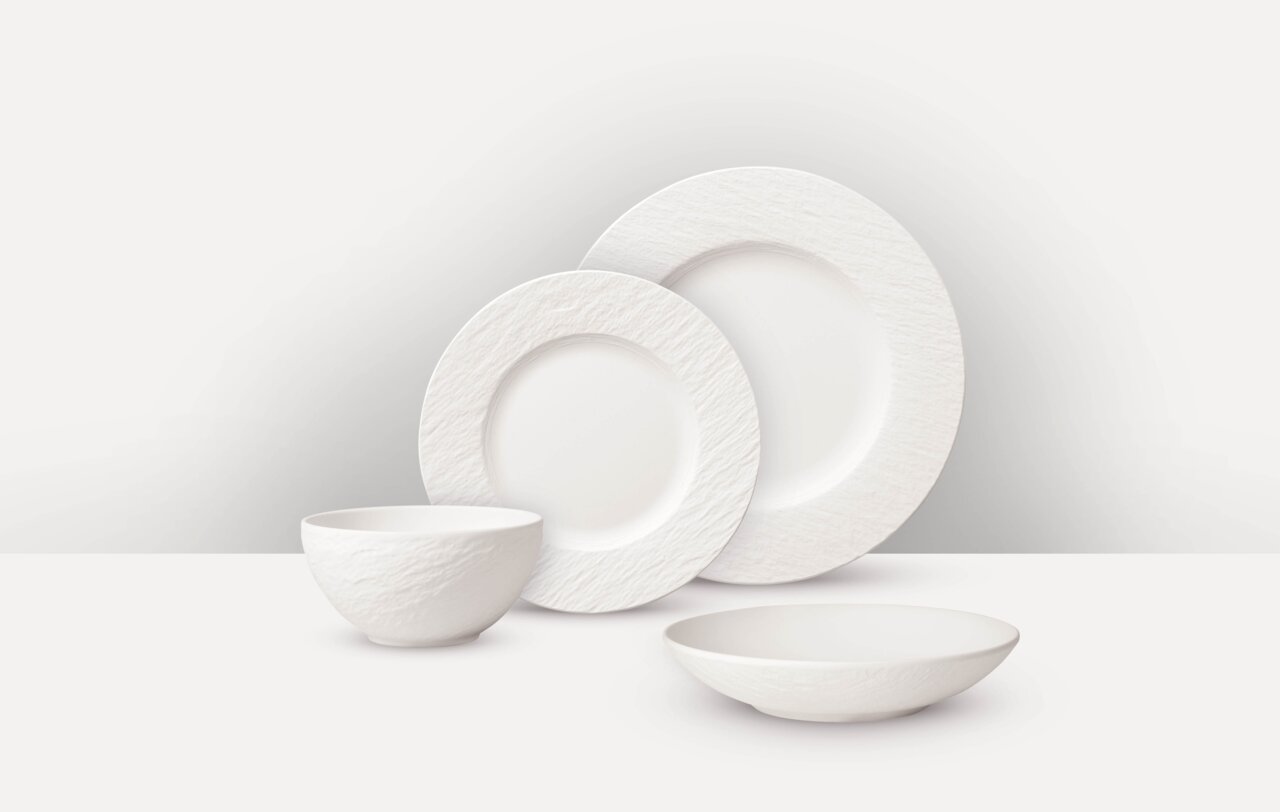 Villeroy & Boch Tafelservice 16-tlg. MANUFACTURE ROCK BLANC Weißes Tafelservice 16-tlg. mit strukturiertem Rand, bestehend aus zwei Tellern, einer Schale und einem tiefen Teller, aus seitlicher Perspektive fotografiert.