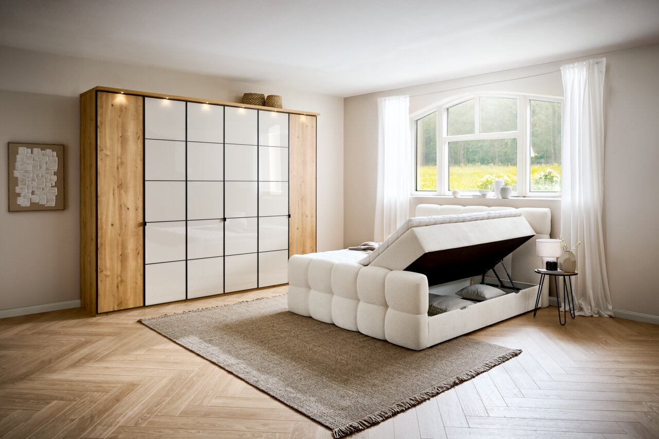 Modernes Boxbett mit Stauraumfunktion in einem hellen Schlafzimmer, seitliche Perspektive.