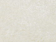 Nahaufnahme eines cremeweißen Uni-Teppichs mit weicher, flauschiger Textur.