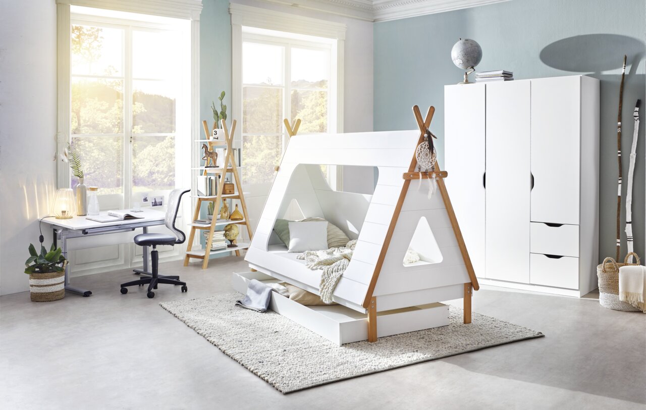 Kinderzimmer mit einem weißen Tipi-Bett, das eine Schublade oder ein Gästebett enthält, in einer hellen und modernen Umgebung. Perspektive von der Seite.