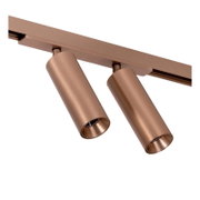 Zwei zylindrische LED-Schienenstrahler in kupfer/roségoldener Metalloptik an Stromschiene, schräg von unten in Nahaufnahme freigestellt