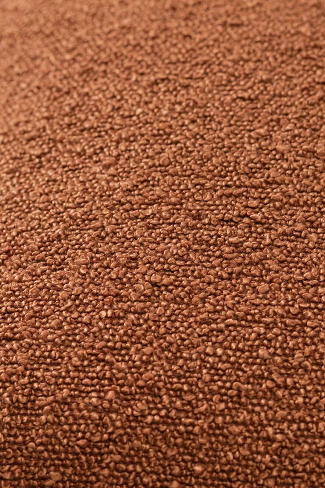 Nahaufnahme einer braunen, strukturierten Stoffoberfläche, vermutlich von einer Zierkissenhülle.
