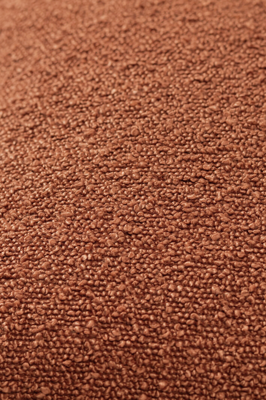 Nahaufnahme einer braunen, strukturierten Stoffoberfläche, vermutlich von einer Zierkissenhülle.