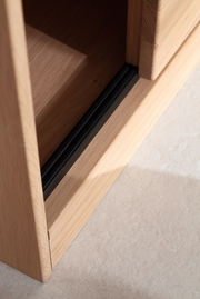Nahaufnahme einer Holzkante mit schwarzem Akzent, perspektivisch von oben fotografiert.