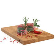 Schneidbrett aus Eiche mit frischen Kräutern und Gewürzen, seitliche Perspektive