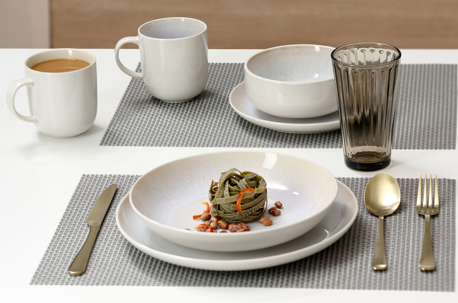 Speiseset 8-tlg. mit Teller, Schüssel, Tasse und Besteck auf einem Tisch, seitliche Perspektive