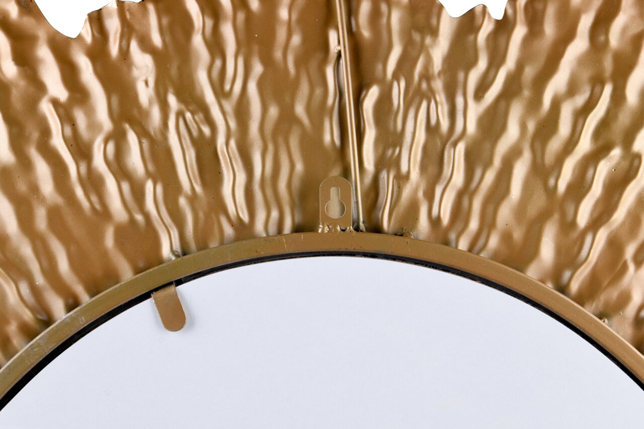 Nahaufnahme eines goldfarbenen, strukturierten Rahmens eines runden Spiegels, von oben betrachtet.