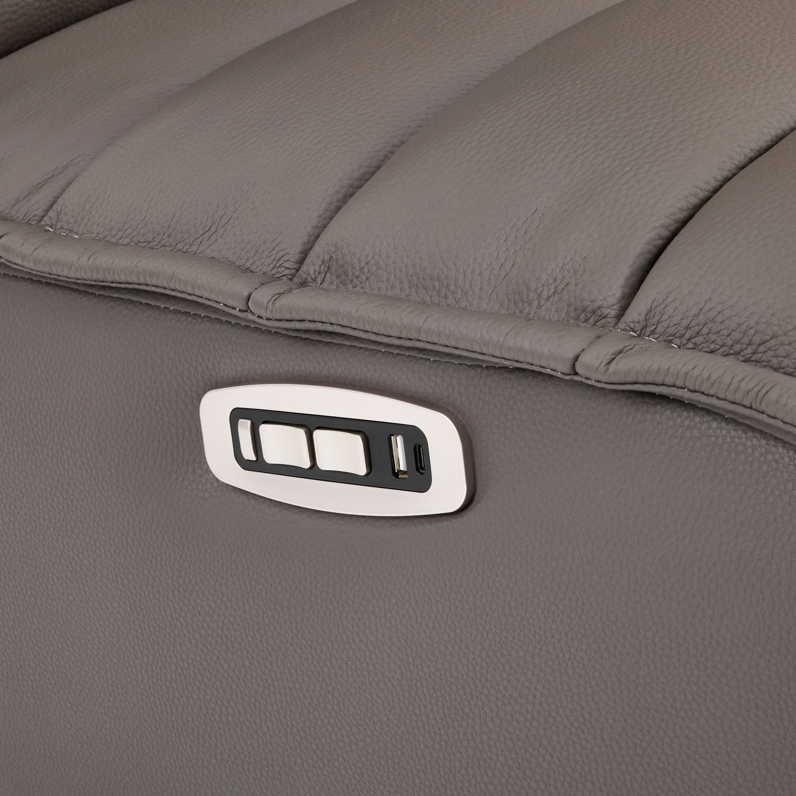 Nahaufnahme einer grauen Relaxliege mit integrierten Bedienelementen und USB-Anschluss an der Seite.