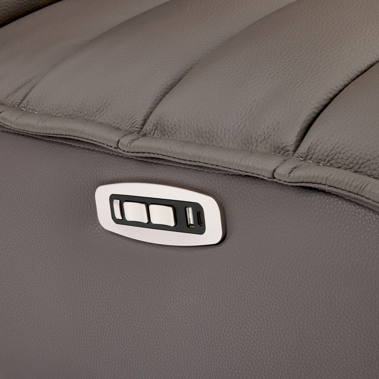 Nahaufnahme einer grauen Relaxliege mit integrierten Bedienelementen und USB-Anschluss an der Seite.