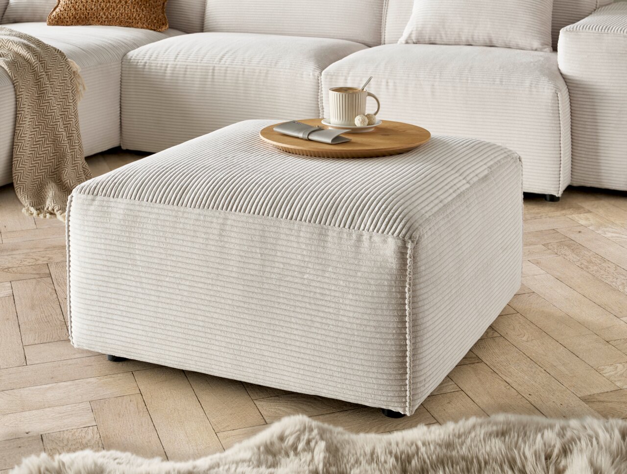 Lounge Handmade Hocker LH-EDINA Beiger Hocker aus Cordstoff in einer gemütlichen Wohnzimmerumgebung, seitliche Perspektive