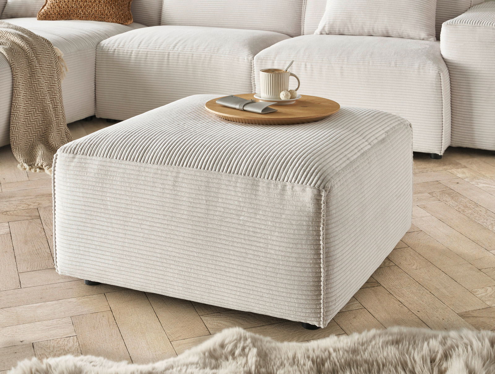 Lounge Handmade Hocker LH-EDINA Beiger Hocker aus Cordstoff in einer gemütlichen Wohnzimmerumgebung, seitliche Perspektive