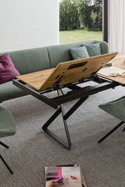 Moderner Esstisch mit verstellbarer Tischplatte in einem Wohnzimmer, seitliche Perspektive.