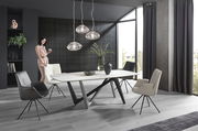 Moderner Essbereich mit stilvollem Tisch und eleganten Sesseln in einem hellen Raum mit großen Fenstern, seitliche Perspektive.