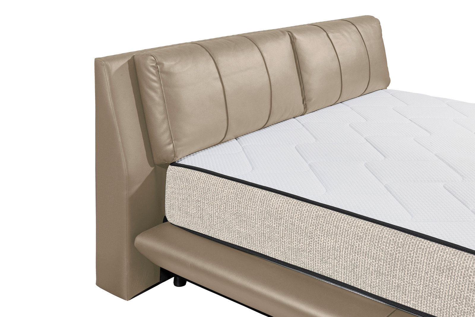 Nahaufnahme eines Polsterbetts mit beigem Kopfteil und weißer Matratze, seitliche Perspektive