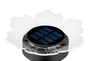 Nahaufnahme einer blumenförmigen Solarleuchte mit transparenten Blütenblättern und einem zentralen Solarpanel, von oben betrachtet.