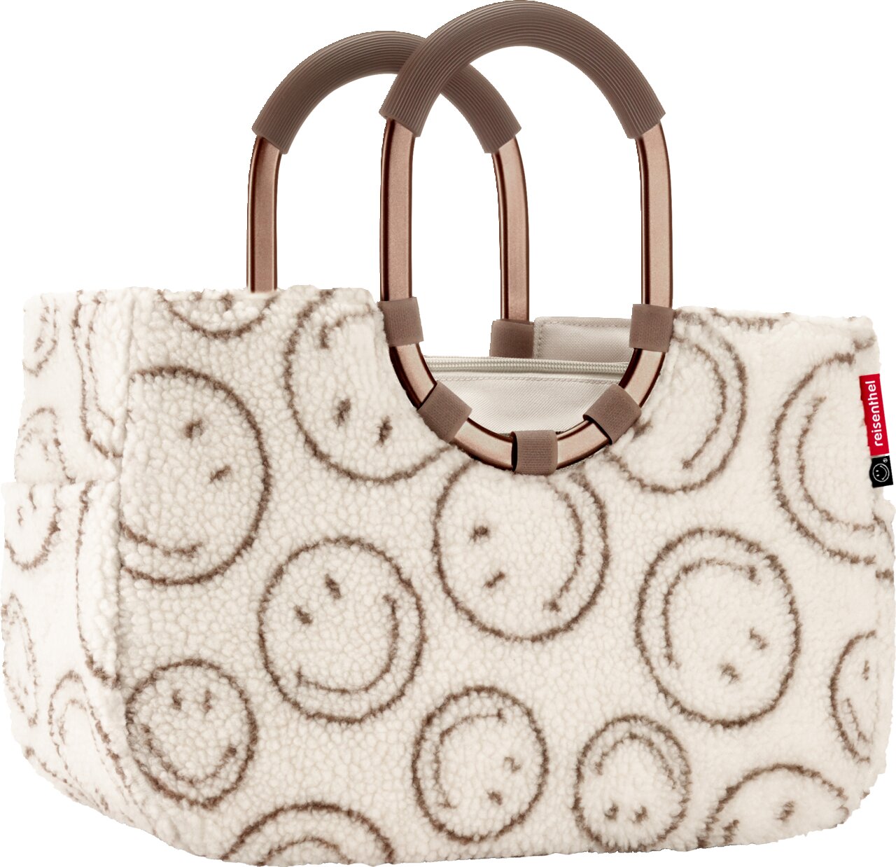 Frontansicht einer cremefarbenen Teddyfell-Shopper-Tasche mit grauem Smileymuster, zwei braunen Rundgriffen mit geriffelter Griffzone und Reißverschluss oben seitliches rotes Label sichtbar
