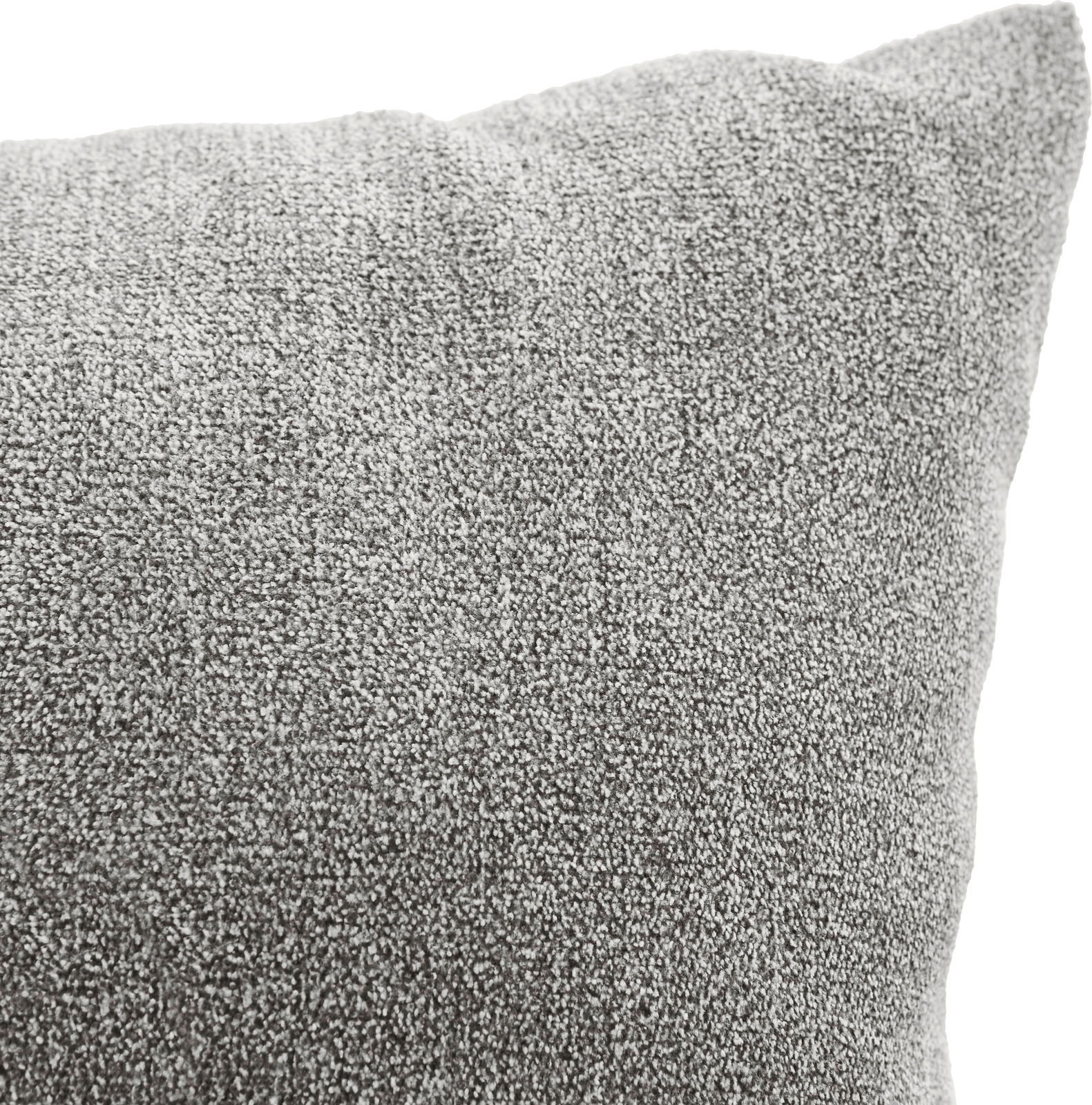 Nahaufnahme eines grauen Sofakissens mit weicher Textur, perspektivisch von der Seite aufgenommen.