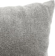 Nahaufnahme eines grauen Sofakissens mit weicher Textur, perspektivisch von der Seite aufgenommen.