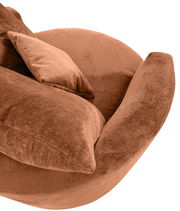 Nahaufnahme eines braunen Sessels mit weichem Stoffbezug und passendem Kissen, seitliche Perspektive.